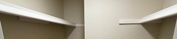 A corner of a room with a grey floor and white walls.